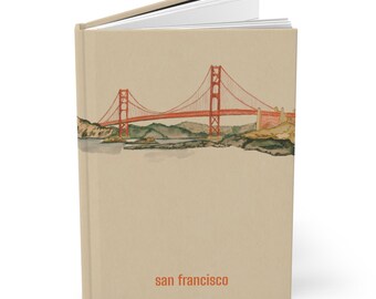 May include: A hardcover journal with a tan cover featuring a watercolor illustration of the Golden Gate Bridge in San Francisco. The bridge is red, and the text "san francisco" is printed in orange at the bottom.