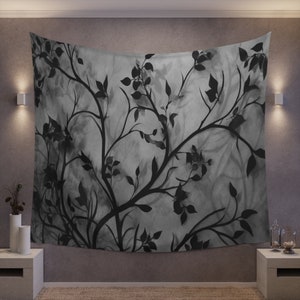 May include: A black and white tapestry featuring a stylized floral design with branches and leaves. The tapestry has a watercolor effect, giving it a soft and ethereal look.