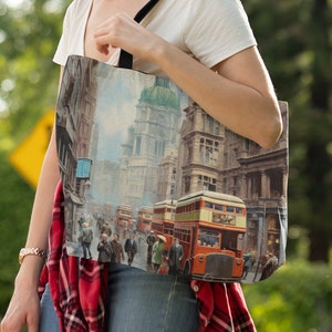 May include: A tote bag featuring a vintage illustration of a city street scene with red double-decker buses and buildings.