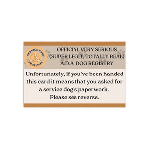 以下が含まれることがあります： 茶色の縁と白い内側の長方形のカード。カードには「OFFICIAL VERY SERIOUS (SUPER LEGIT, TOTALLY REAL) A.D.A. DOG REGISTRY」というテキストが記載されています。ロゴと追加のテキストも含まれています。