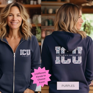 May include: Navy blue zip-up hoodie with floral "ICU" design on the front and back. The back also features "intensive care unit" text. The design is in shades of blue, purple, and white. The text "2 Different Florals to Choose from!" is also visible.