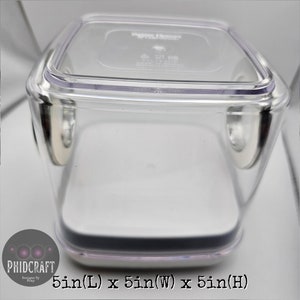 Peut inclure: Un r&eacute;cipient de rangement en plastique transparent avec un couvercle noir et une base blanche. Le r&eacute;cipient mesure 12,7 cm de long, 12,7 cm de large et 12,7 cm de haut.