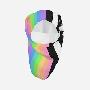 May include: A balaclava featuring a split design. One side displays vertical stripes in a rainbow gradient of pink, orange, yellow, green, blue, and purple. The other side features a bold, high-contrast black and white abstract graphic pattern.