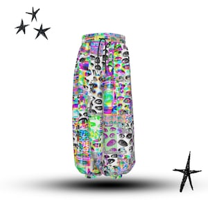 May include: Vibrant patterned sweatpants with an eye design. The trousers have a drawstring waist and a colourful mix of pink, green, blue, and yellow. The design is a collage of eye images. Black star doodles are in the background.