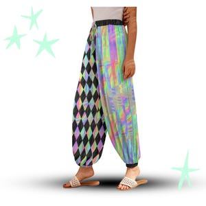 May include: Harem trousers with a distinctive design. One leg has a black and grey diamond pattern, the other a vibrant, iridescent rainbow design. The trousers have a drawstring waist and a relaxed fit.