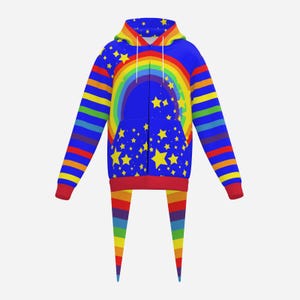 May include: A zip-up hoodie featuring a vibrant blue base with a large rainbow arch and scattered yellow stars across the front and hood. The sleeves and two long, pointed tail-like extensions at the hem display horizontal rainbow stripes.
