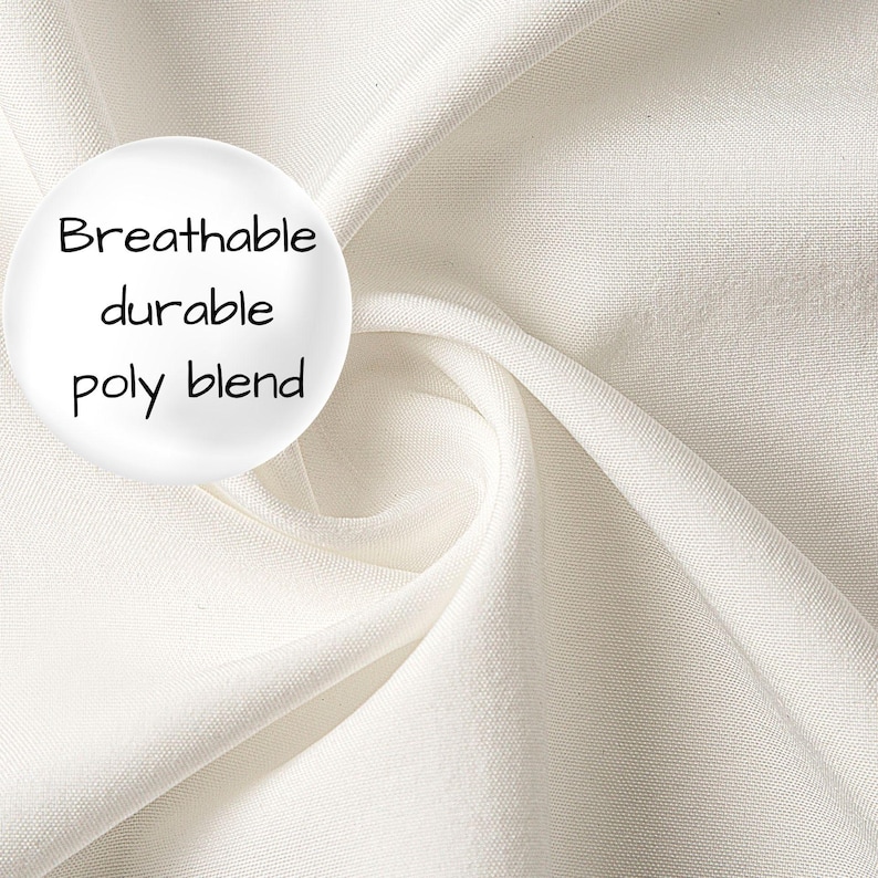 Op de afbeelding: Een effen gebroken witte stof met een gladde, geweven textuur en zachte plooien. Aan de linkerkant bevindt zich een cirkelvormige witte grafische overlay met de zwarte tekst: Breathable durable poly blend. Het materiaal oogt ondoorzichtig en egaal.