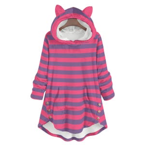 Op de afbeelding: Een gestreepte hoodie met een kattenoordesign. De roze en paarse gestreepte kleding heeft een kangoeroezak en houten knopen. De capuchon is gevoerd met witte stof. De mouwen zijn gerimpeld bij de polsen.