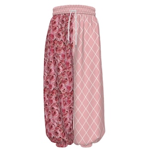 May include: Pink and white patterned pants with a drawstring waist. One leg features a pattern of pink roses, while the other has a pink diamond grid design. The pants have a gathered ankle and waist.