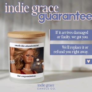 K&ouml;nnte beinhalten: Ein Glas-Kerzenglas mit Holzdeckel. Das Etikett lautet "smells like abandonment" mit einem Foto einer Puppe, die ein Gesicht macht. Der Text "but congratulations" steht unter dem Bild. Der Markenname "indie grace CANDLE CO." steht unten.