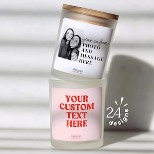 May include: Two custom candles stacked on top of each other. The top candle has a photo and the text "your custom PHOTO AND MESSAGE HERE". The bottom candle has the text "YOUR CUSTOM TEXT HERE". Both candles are white with a wooden lid.