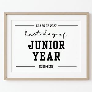 Peut inclure: Une impression encadrée avec le texte CLASS OF 2027, last day of JUNIOR YEAR et 2025-2026 en encre noire sur fond blanc. Le cadre est de couleur bois clair avec un design simple et épuré entourant l'insert en papier blanc rectangulaire.