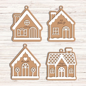 Op de afbeelding: Vier peperkoekhuisornamenten met witte glazuurdetails. Eén zegt "welcome", een andere heeft "143 Baker St", een derde zegt "the smiths" en de laatste zegt "home sweet home". Elk heeft een klein gaatje om op te hangen.