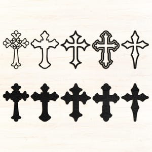 May include: Ten decorative crosses in various designs. Some are outlined, while others are solid black. The crosses are arranged on a light wood-grain background. The designs range from simple to ornate, suitable for religious or decorative purposes.