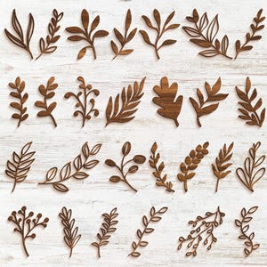 May include: A collection of various wooden leaf and branch cutouts in shades of brown. The leaves and branches are arranged on a white, wood-grain background. The cutouts vary in size and style, suitable for crafting or decor.