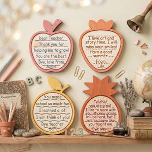 May include: Four wooden teacher appreciation plaques shaped like an apple, strawberry, pineapple, and lemon. Each plaque has a handwritten message. The strawberry plaque says "I love art and story time. I will miss your smiles!"