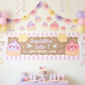 May include: A birthday party decoration set featuring a large banner with the text Squishin' into 7 HAPPY BIRTHDAY, OLVIA!, pastel balloons, paper fans, and small character cutouts. The theme includes smiling, glittery dumpling-like figures.