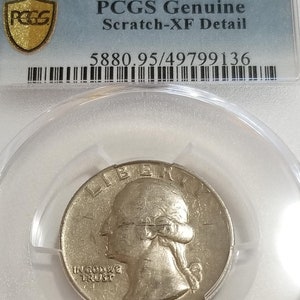 Może przedstawiać: Srebrna moneta 25-centowa z 1967 roku, oceniona przez PCGS jako Genuine Scratch-XF Detail z oceną 5880.95/49799136. Moneta przedstawia profil Lady Liberty z napisem "IN GOD WE TRUST" i rokiem "1967".