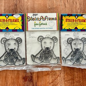 May include: Three packs of Stain-A-Frame fun forms for making stained glass ornaments. Each pack features a different animal design: a bear, a bird, and a fish. The packs are labelled with the words "Stain-A-Frame" and "fun forms".