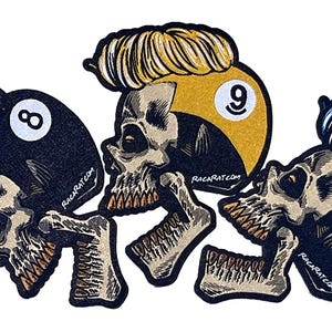 May include: Three skull-shaped patches with different colored hair and a billiard ball number on each. The patches are black, yellow, and blue. The text on the patches reads "RackRat.com".