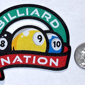May include: A green and black embroidered patch with the words "Billiards Nation" and three billiard balls, one yellow, one white with a black "9", and one blue with a white "10".