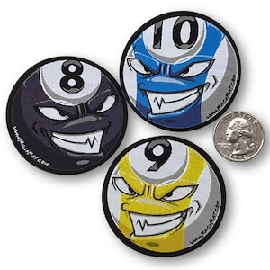 May include: Three embroidered patches featuring cartoon faces of billiard balls. The patches are black, blue, and yellow with white numbers 8, 10, and 9. Each patch has a website address printed on the bottom.