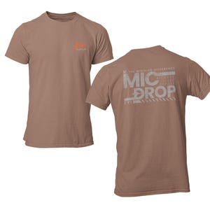 May include: A brown t-shirt with a white graphic on the back that says "The Winning Difference: Mic Drop".