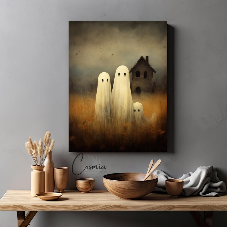 May include: A canvas print featuring a spooky Halloween scene. Three white ghost figures stand in a field of tall, dry grass, with a haunted house in the background. The artwork has a muted color palette with a vintage aesthetic.