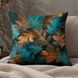 May include: A square throw cushion featuring a dense, overlapping pattern of oak leaves. The leaves are rendered in vibrant shades of teal, turquoise, and warm copper-brown, set against a deep, dark navy blue background that creates a high contrast.