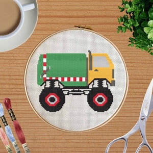 May include: A green and yellow toy garbage truck with red and white stripes on the side. The truck has large black wheels with red centers.