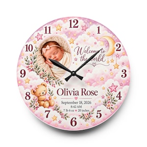 May include: A round wall clock featuring a pink cloud and star background, a photo of a newborn, a teddy bear, and the text Welcome to the world, Olivia Rose, September 18, 2026, 8:42 AM, 7 lb 6 oz, 20 inches, with black clock hands.