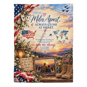 Pode incluir: Uma manta retangular de lã com tema patriótico, bandeira americana, placas de identificação militares, um mapa e uma paisagem ao pôr do sol. O texto diz: Miles Apart, ALWAYS CLOSE AT HEART, e inclui uma foto emoldurada de uma família e botas militares.