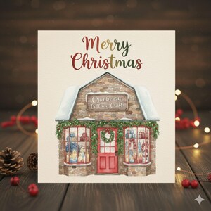 May include: A Christmas card featuring a watercolor illustration of a shop with the text "Merry Christmas." The shop has a brick facade, snow-covered roof, and a red door. The windows display gifts and decorations.