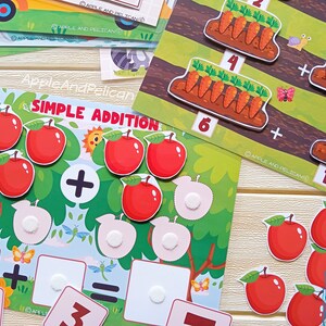 May include: A colorful educational game for kids featuring a simple addition problem with apples. The game includes a green tree with red apples, a plus sign, and blank spaces for the answer. The text "Simple Addition" is printed on the game board.