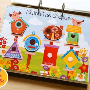 May include: A colorful educational activity book with the title "Match The Shapes". The book features various birdhouse shapes, including a triangle, rectangle, and diamond. Includes a pink and blue marker.