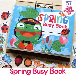 May include: A colorful "Spring Busy Book" with a frog character on the cover, surrounded by spring-themed illustrations. The book is held open with a metal binder. The text "57 PAGES DIGITAL DOWNLOAD PDF" is visible. Additional spring-themed cutouts are scattered around.