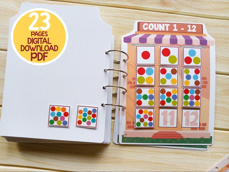 K&ouml;nnte beinhalten: Ein farbenfrohes Z&auml;hlbuch mit 23 Seiten. Das Buch zeigt eine Ladenfront mit einem Schild, auf dem "COUNT 1 - 12" steht. Die Ladenfront hat 12 Quadrate mit verschiedenen farbigen Punkten in jedem Quadrat. Das Buch ist ein digitaler Download im PDF-Format.