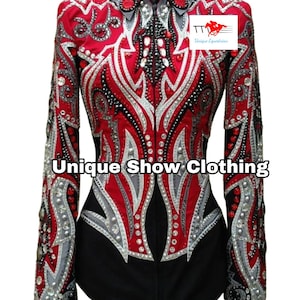 Könnte beinhalten: Ein rotes, schwarzes und silbernes Reitturniershirt mit aufwendigen Verzierungen. Das Shirt hat ein detailliertes Design mit Strasssteinen und dekorativen Mustern. Der Text "Unique Show Clothing" ist auf der Vorderseite abgebildet.