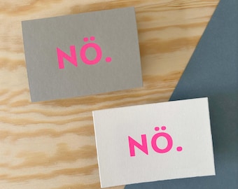 Postal serigrafiada con un diseño tipográfico sencillo, tarjeta con el término "Nö", impresa a mano y estampada con el logo en el reverso