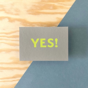 Siebdruck-Postkarte im schlichten typografischem Design, Spruch-Karte mit dem Begriff "Yes!", handbedruckt, Rückseite mit Logo bestempelt