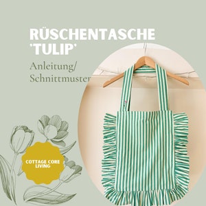Puede incluir: Una bolsa de mano de rayas verdes y blancas con un borde de volantes. La bolsa tiene un asa de madera y está colgada de una percha. El texto "Rüschen Tasche 'TULIP' Anleitung/Schnittmuster" es visible en la esquina superior izquierda de la imagen. El texto "COTTAGE CORE LIVING" es visible en la esquina inferior izquierda de la imagen.