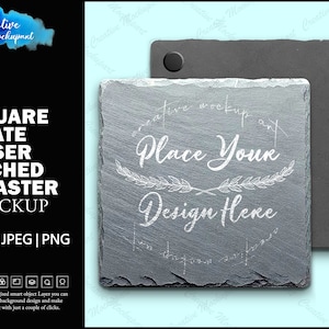 May include: A square slate coaster mockup with a laser etched design that says "Place Your Design Here". The coaster is gray and has a rough texture. The mockup is on a white background.