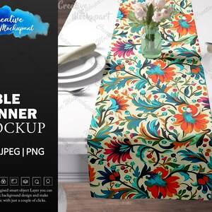 May include: A mockup of a table runner with a floral pattern. The runner is on a white table with two plates and a vase of flowers. The runner is a light cream color with a blue, orange, and red floral pattern.