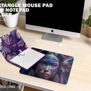 Op de afbeelding: Een rechthoekig muismat met een notitieblokhouder. De muismat heeft een kleurrijk abstract ontwerp met het gezicht van een vrouw. De notitieblokhouder is in een paars en roze bloemenontwerp.