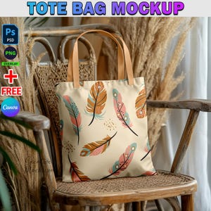 May include: A beige tote bag with a colorful feather pattern. The bag has brown straps and is sitting on a wooden chair with a woven seat.