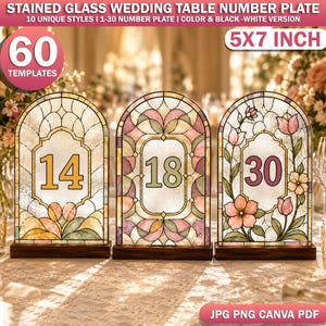 May include: Three arched stained glass wedding table number plates measuring 5x7 inches. The plates feature numbers 14, 18, and 30 in decorative frames with floral and geometric patterns in soft pink, green, and yellow hues on wooden bases.