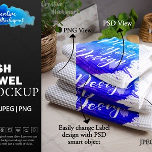 Op de afbeelding: Een mockup van een witte theedoek met een blauw aquarelontwerp met de tekst "Place your design". De theedoek is drievoudig gevouwen en ligt op een wit oppervlak. De afbeelding is gelabeld met "JPEG View", "PNG View" en "PSD View".