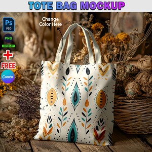 May include: A white tote bag with a colorful floral pattern. The bag has two handles and is made of canvas. The bag is sitting on a wooden surface with dried flowers and a wicker basket.