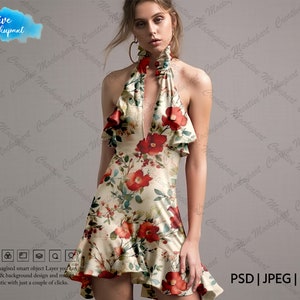 May include: A floral print halter dress with a ruffled neckline and a short skirt. The dress is white with red, green, and yellow flowers.