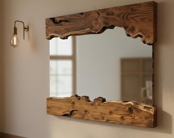 May include: Rectangular mirror with a natural wood frame. The frame has a live edge design, showcasing the wood's unique grain and texture. The mirror is mounted on a neutral-colored wall, with a gold-toned sconce to the left.